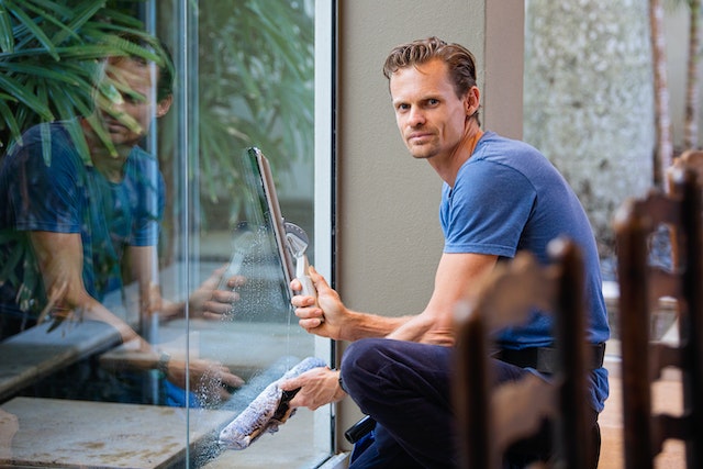 person cleaning large office windows