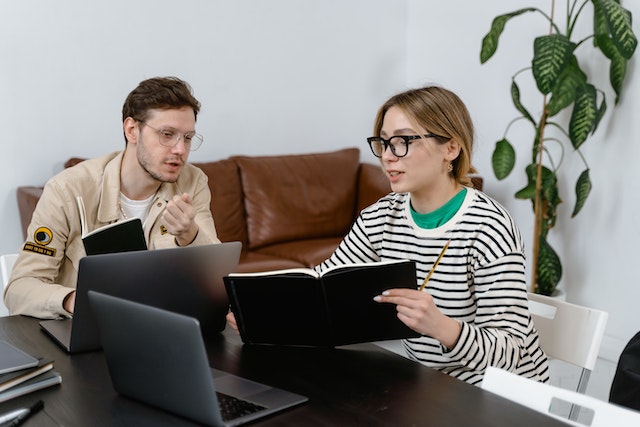 two people discussing over a planner