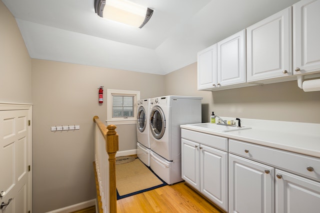 Laundry room with a washer, dryer, sink and white countertops
